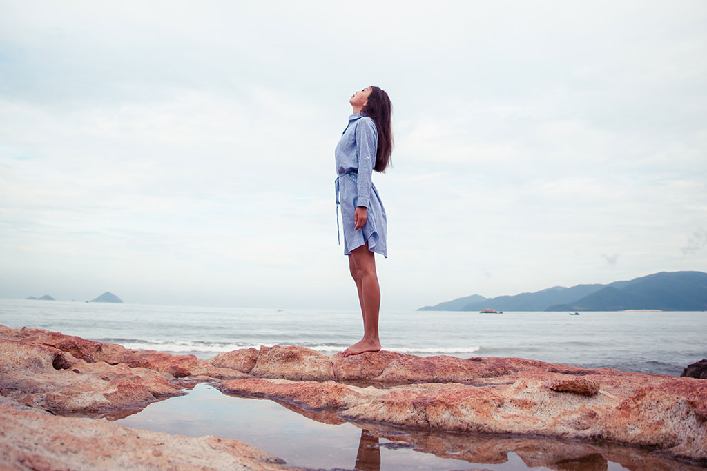woman meditating by water