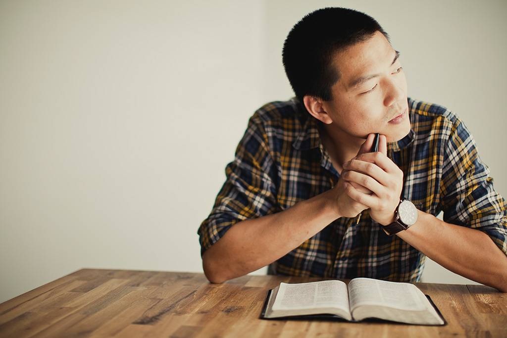 Man reflecting as he's reading the Bible