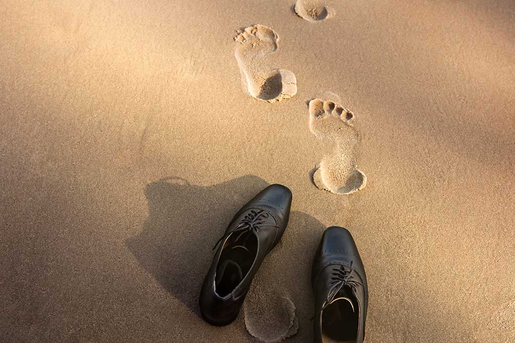 Taking shoes off and walking on sand
