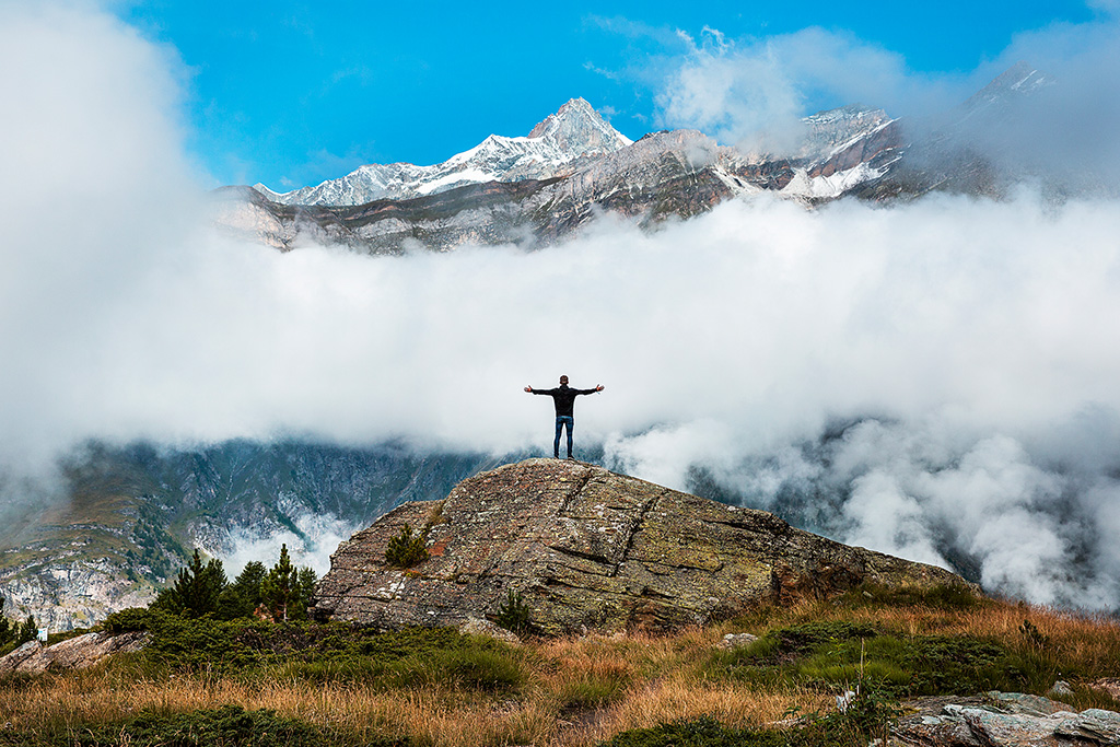 Man with arms out on the mountain representing feeling valued by God