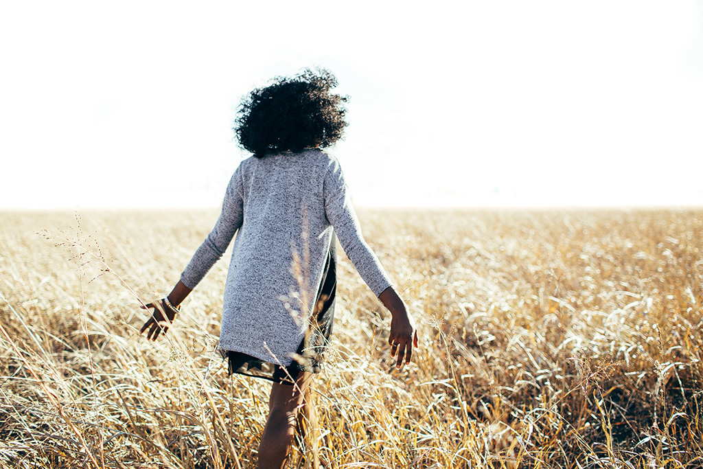 Woman walking in a field full of love, joy and peace