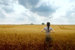 woman looking out into field assessing what she's been given