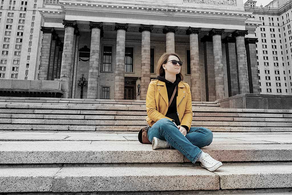 Young person in front of a university building