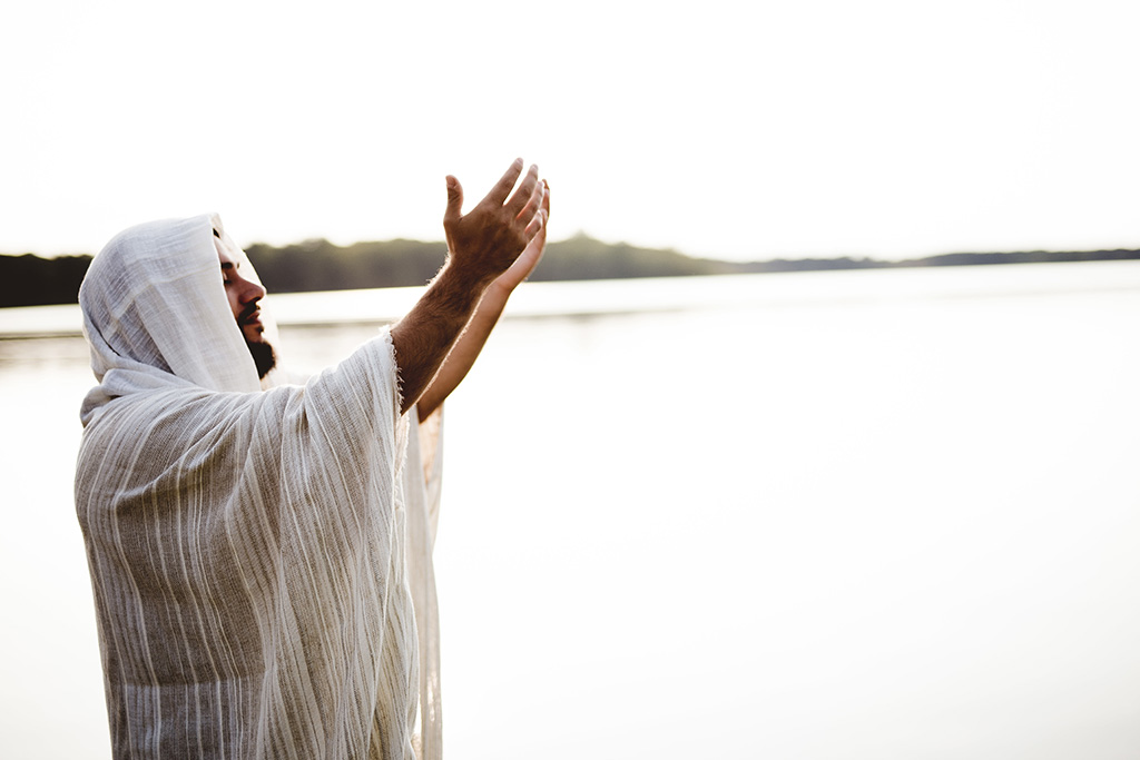 Man praying by the water