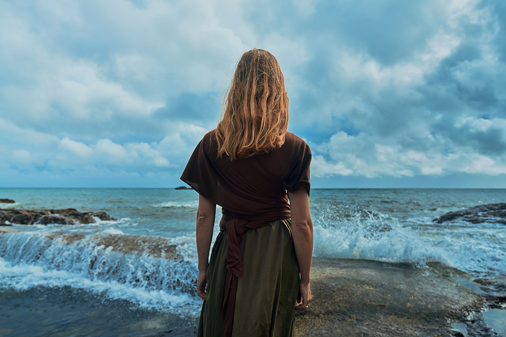 Anxious woman looking out into rough waters