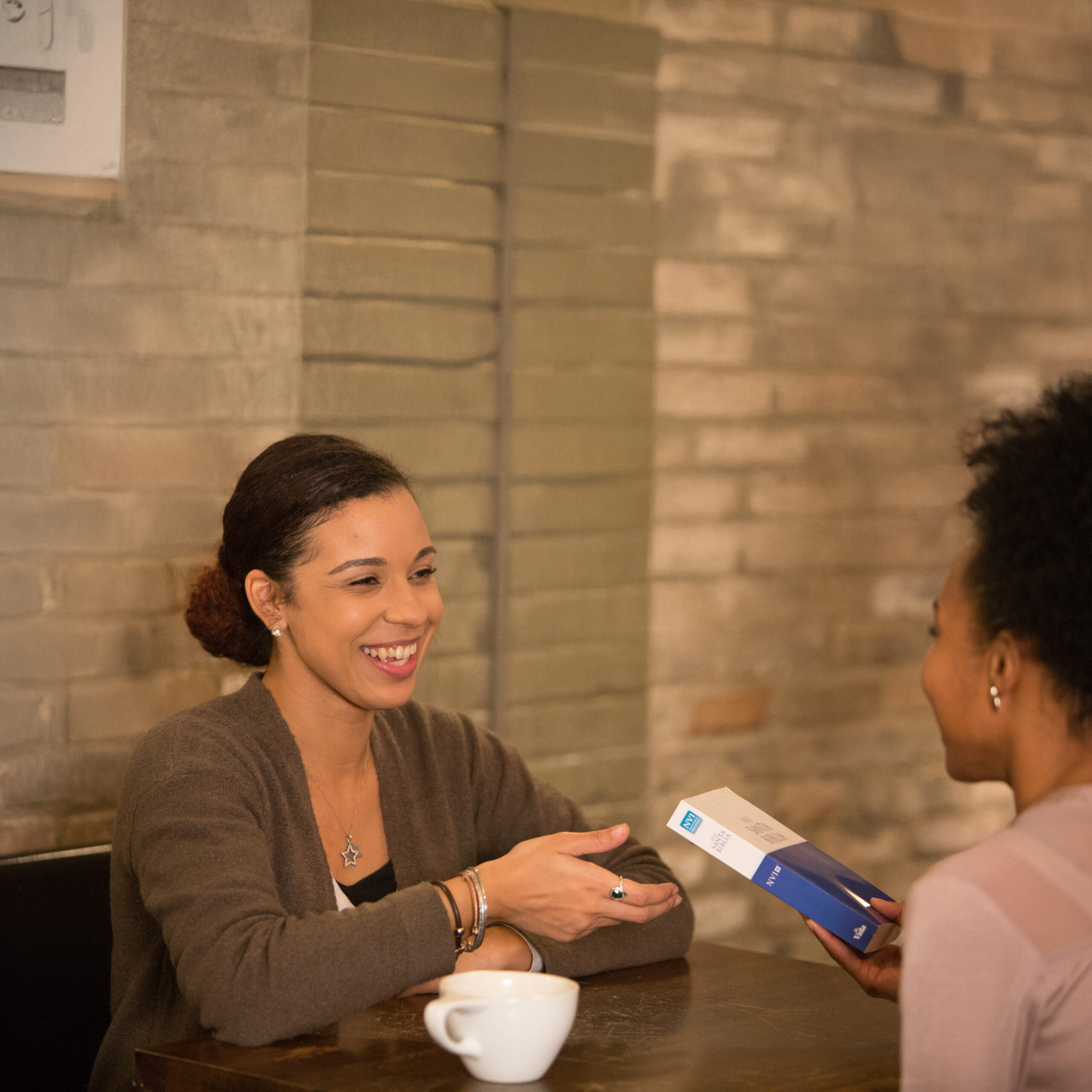Woman giving another woman a Bible